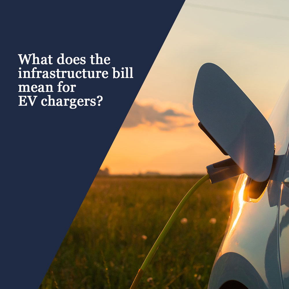 EV chargers and infrastructure bill, EV being charged in field during a sunset