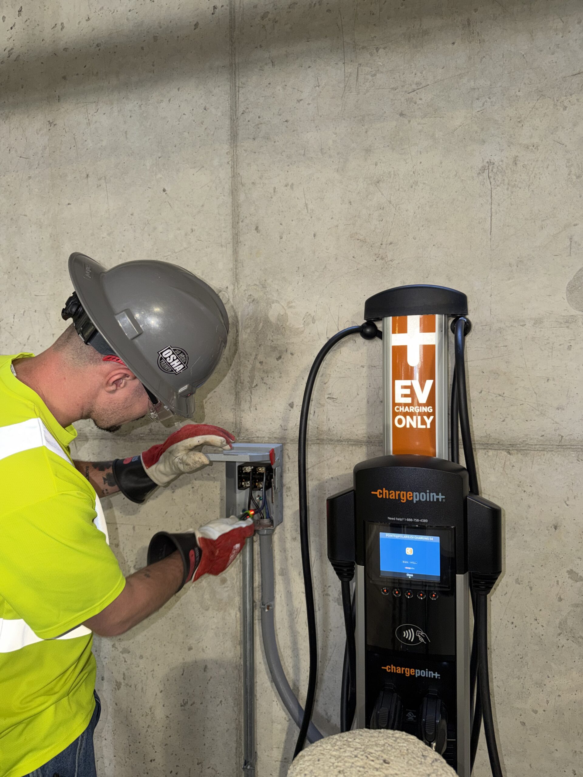 Heartland technician working inside an open charger electrical cabinet